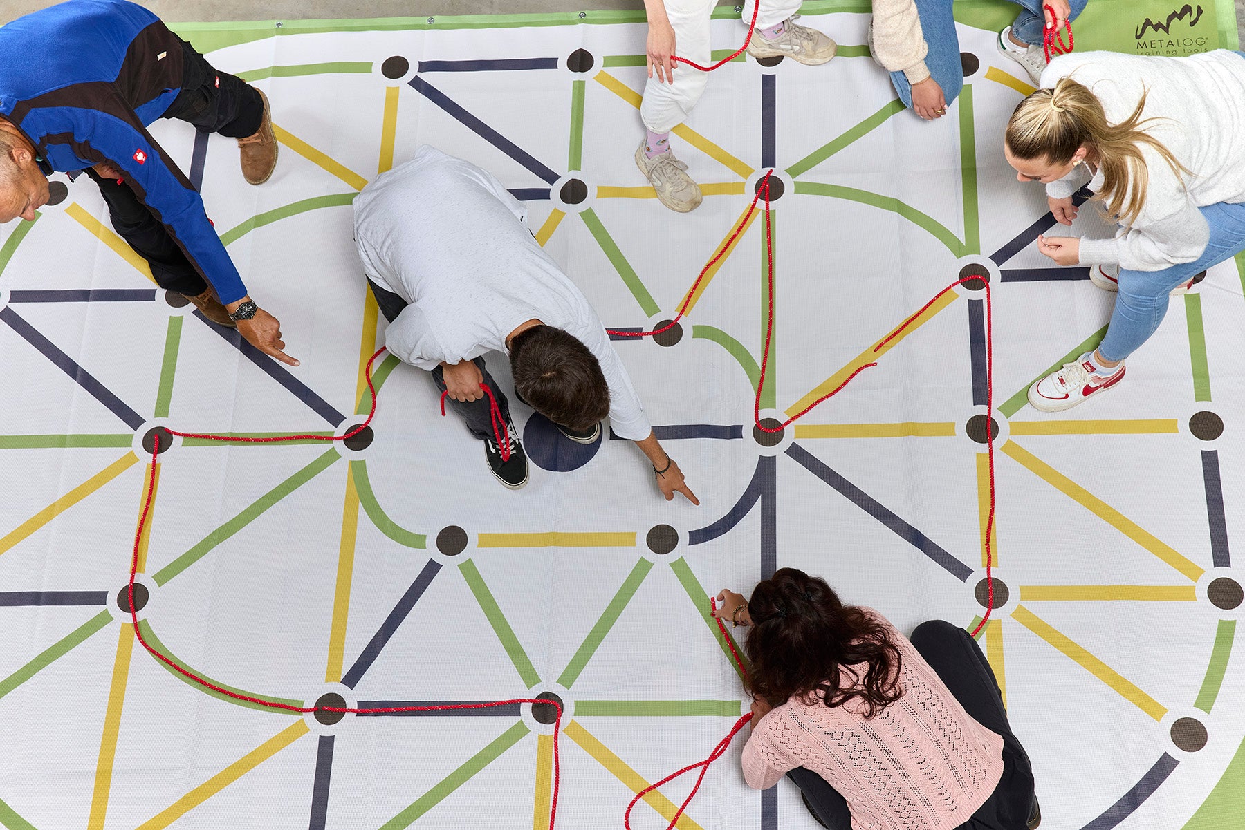 Top down view of maze activity on floor, with some adults inside suggesting routes