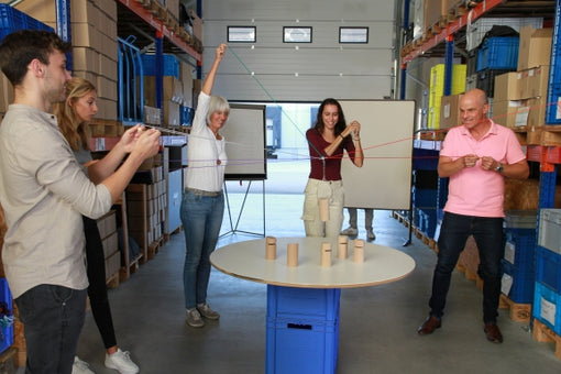 Several people use Tower of Power Mini to stack miniature blocks into a single, stable tower.