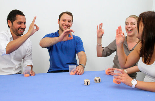 Four adults sit at table, play game CultuRallye, a top activity to help with change in workplace
