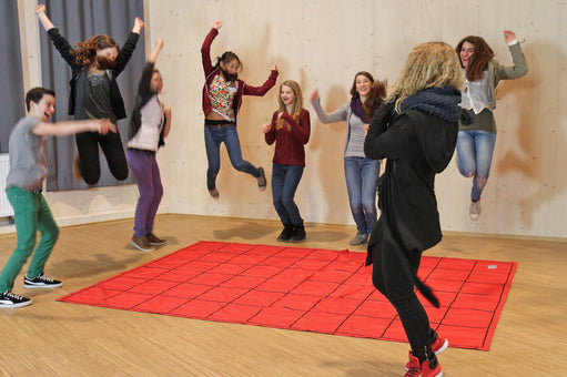 Ten children leap for joy after completing The Maze team learning activity about self organization.