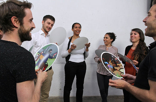 Six adults each hold a picture card from RealityCheck to learn how to see other's perspectives