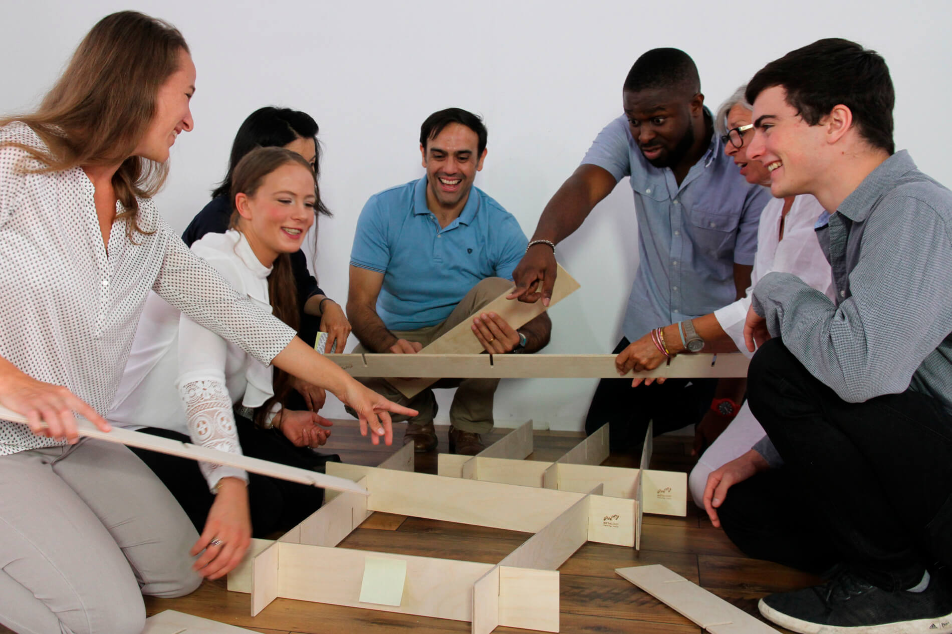 A work team has fun assembling a structure using Metalog StackMan, a collaboration activity