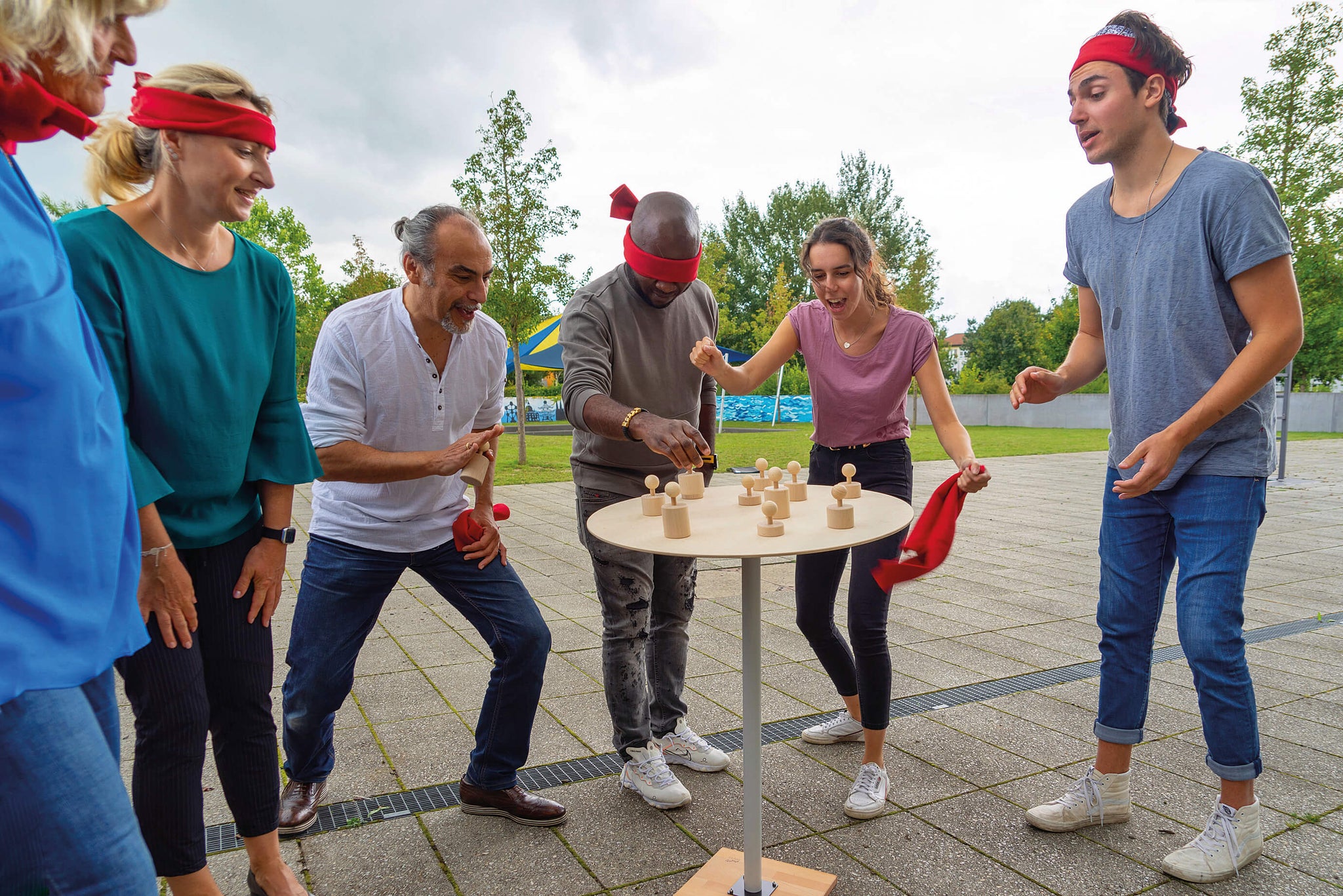 Colleagues, some blindfolded, team to move a figurine in SysTeam, an active listening exercise