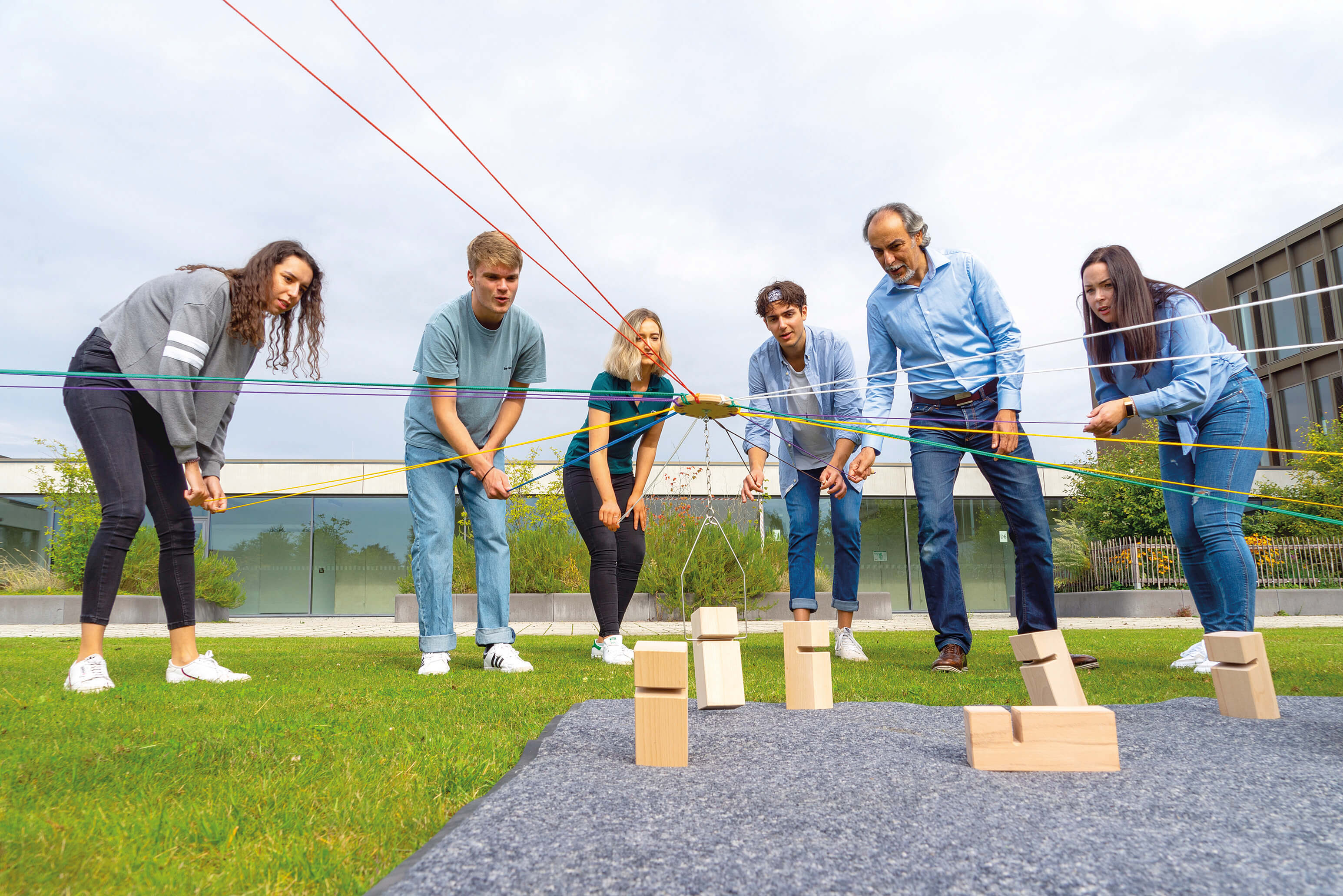 A team of young adults is using Tower of Power outdoors.